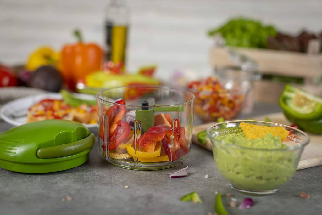 Green pull-cord chopper beside bowls of chopped ingredients and clear container