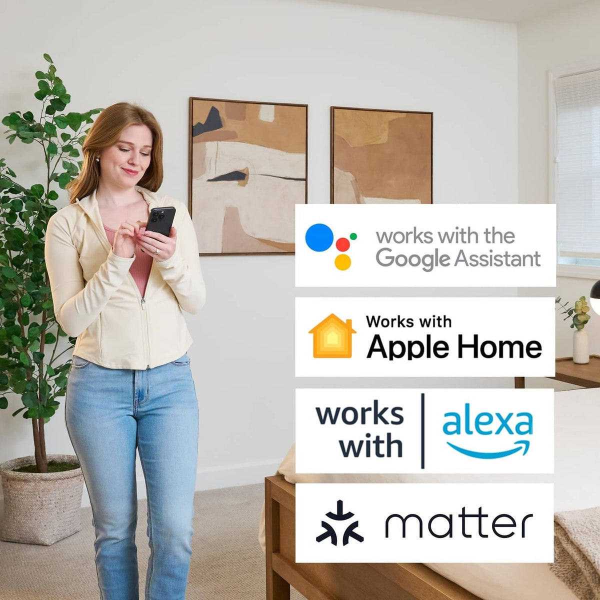 Person holding a smartphone to control a smart thermostat with assistant compatibility icons