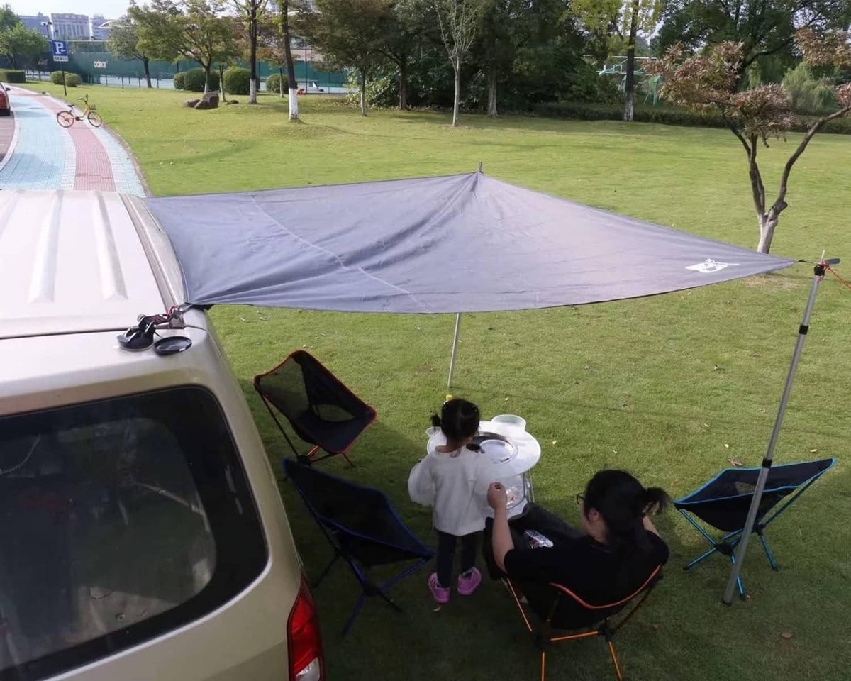 Grey tarp laid on grass under a camping tent setup