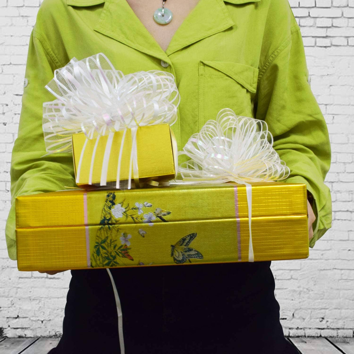 White organza pull bow with striped ribbon tails, large spiral rosette on gift boxes