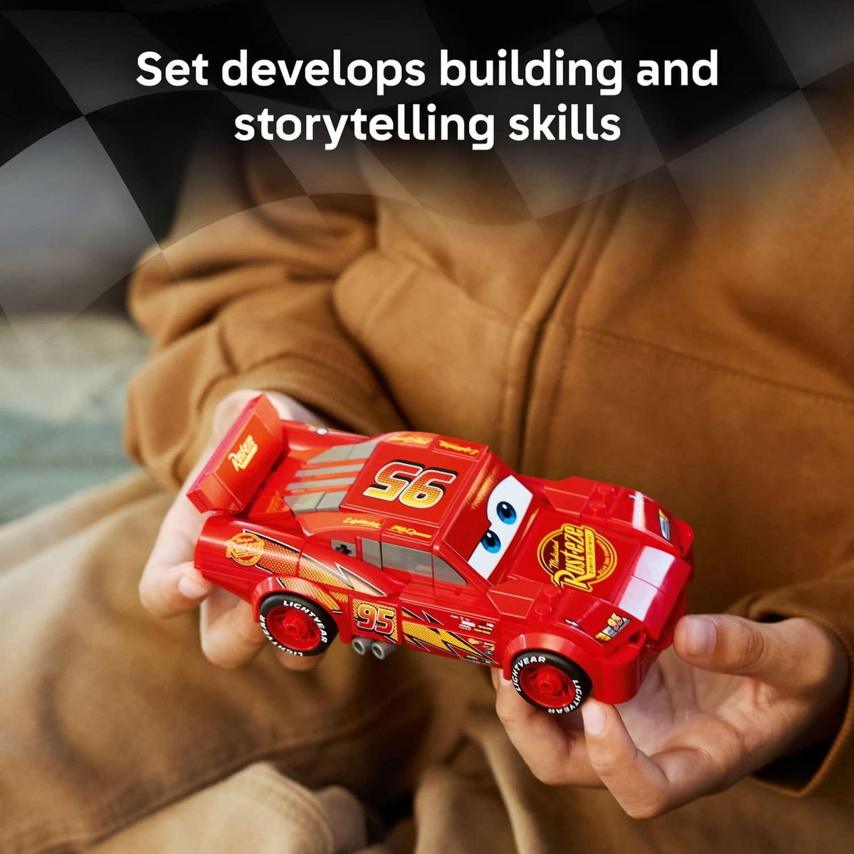 Red buildable race car toy with Lightning McQueen-style face, held in two hands