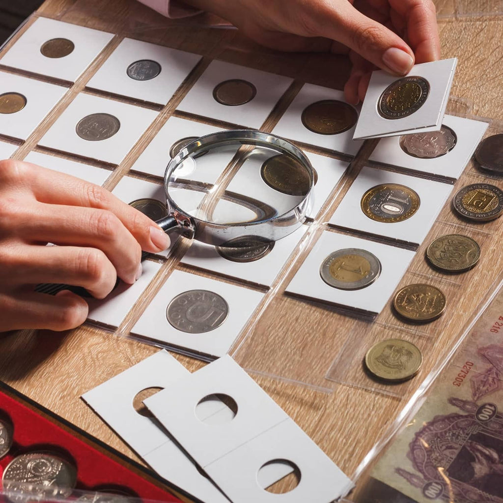 Hands placing a dime into a 2x2 coin flip sleeve laid on a coin collection mat