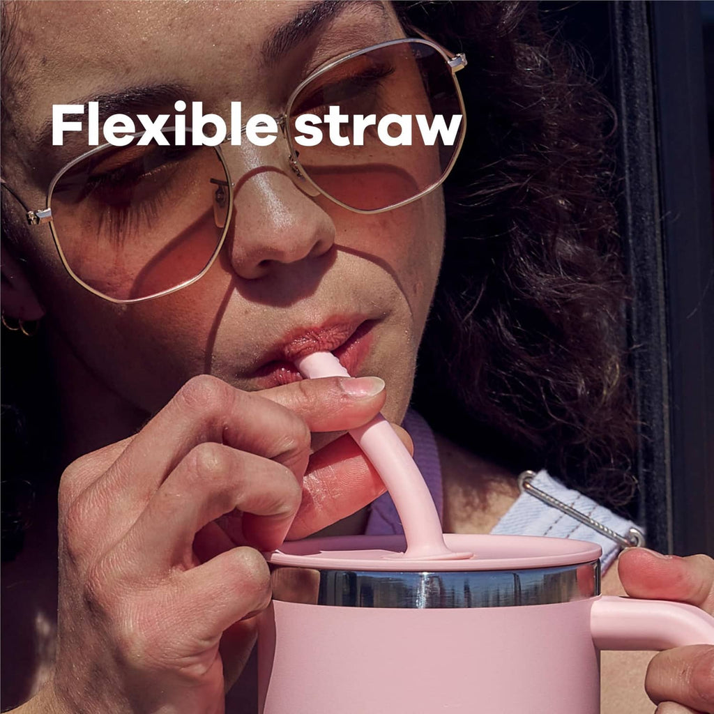 Close-up of a pink travel tumbler with flexible straw and lid while drinking.