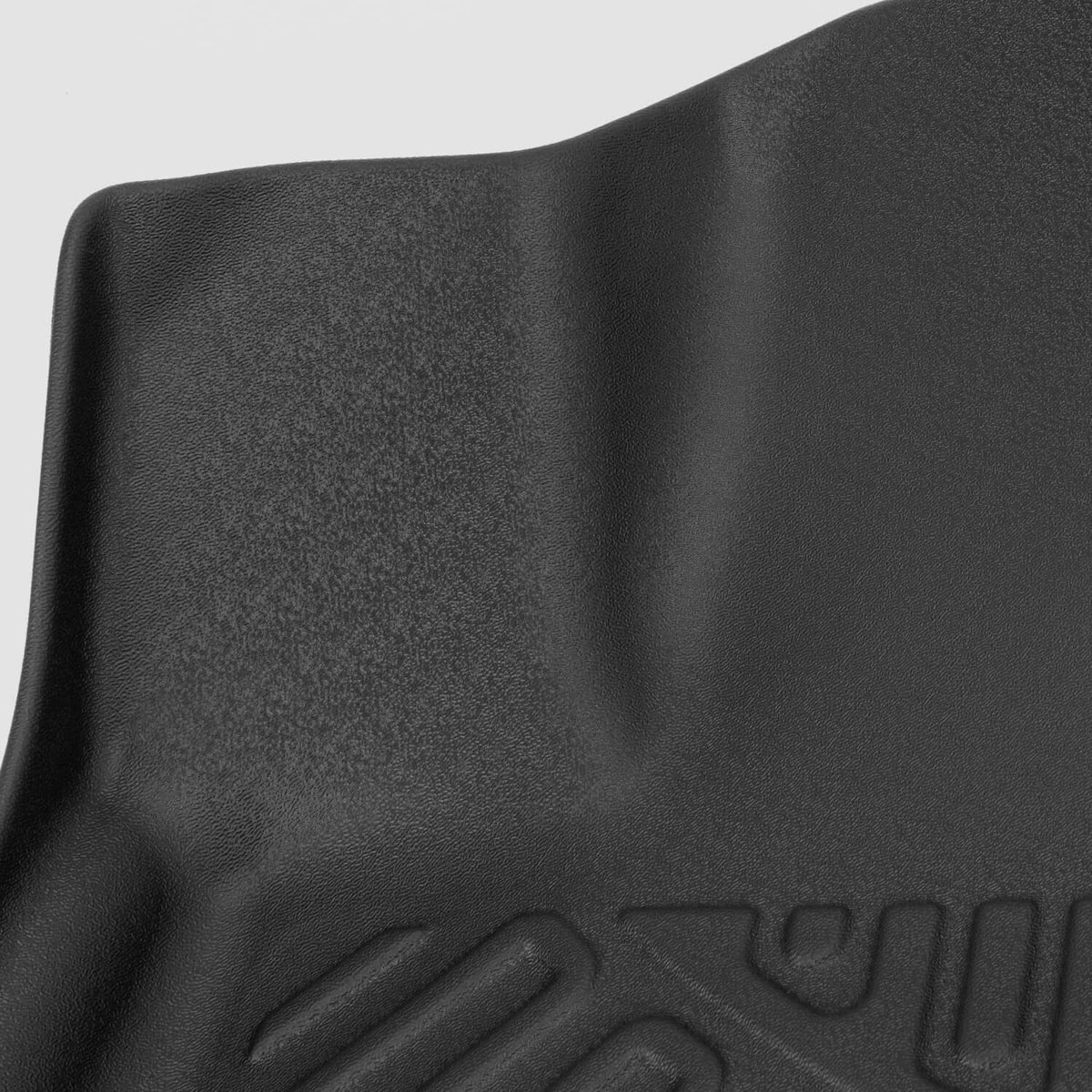 Black rubber floor mat with embossed logo detail and textured surface