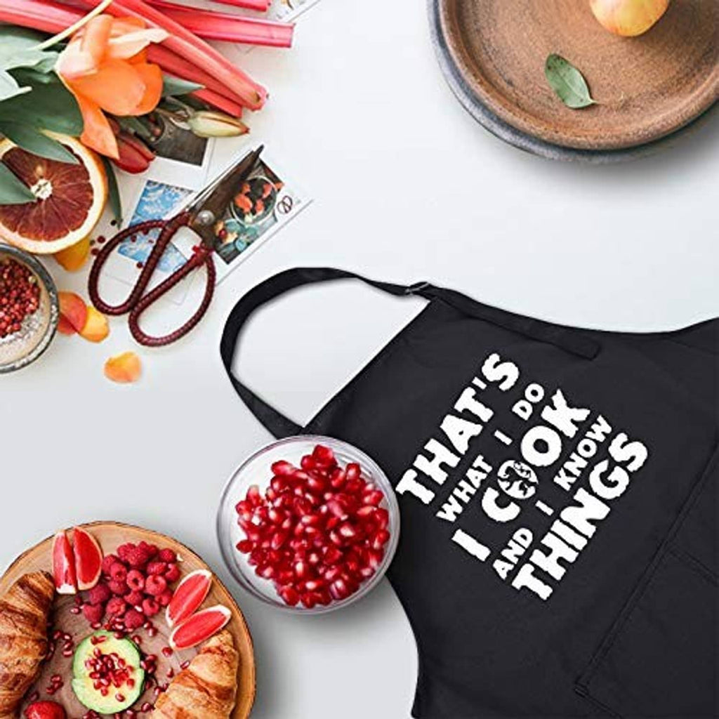 Black chef apron laid flat with bold white 'That's what I do...' slogan