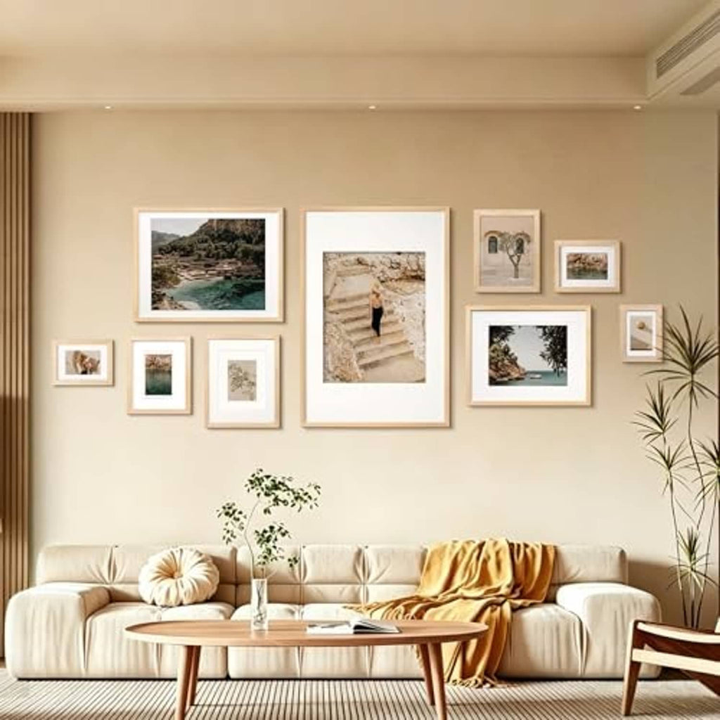 Gallery wall display with natural wood picture frames and white mats above sofa
