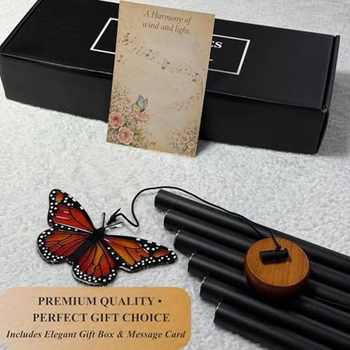 Monarch butterfly wind chime with black tubes and a glass butterfly pendant