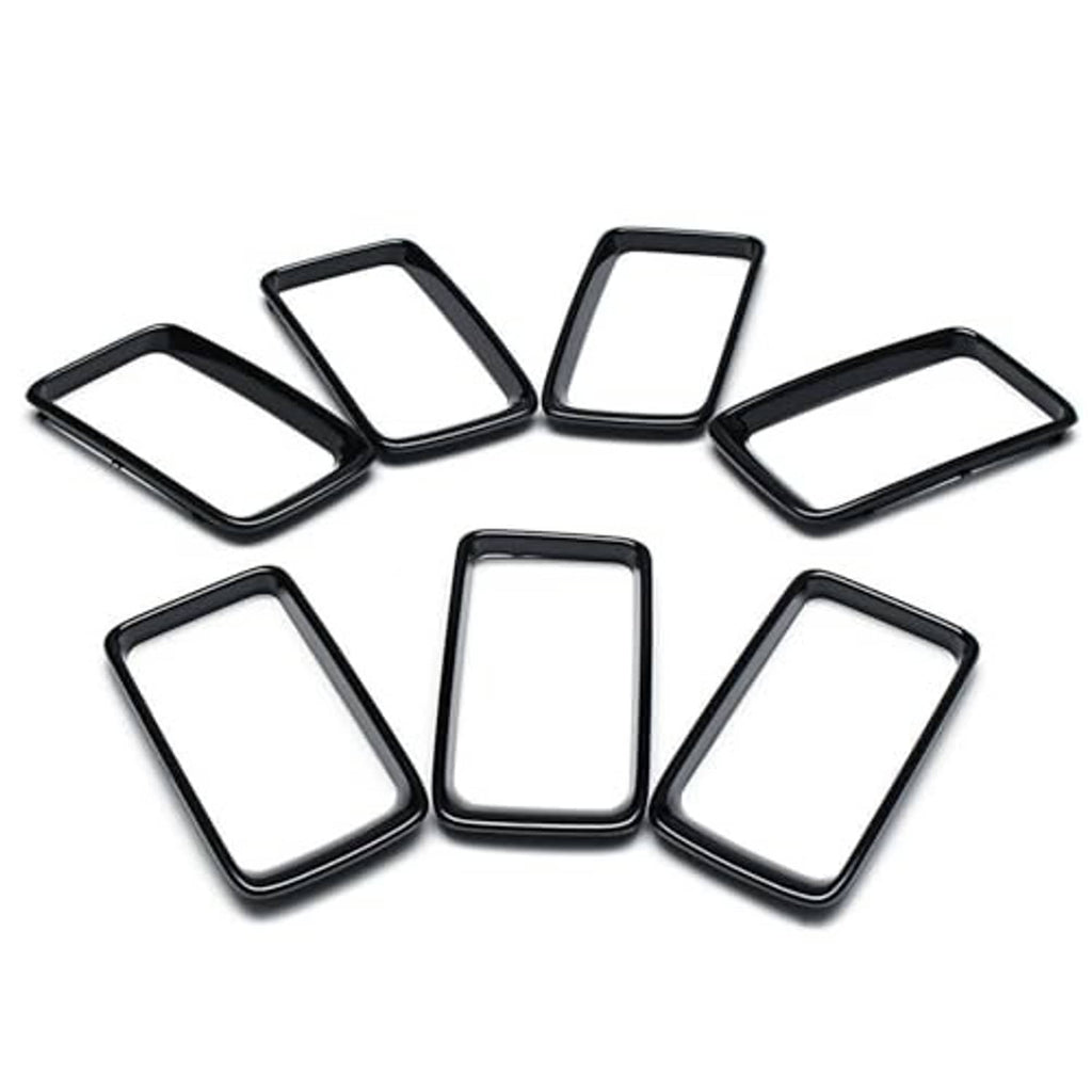 Seven black grille vent insert trim rings with chrome border, flat lay