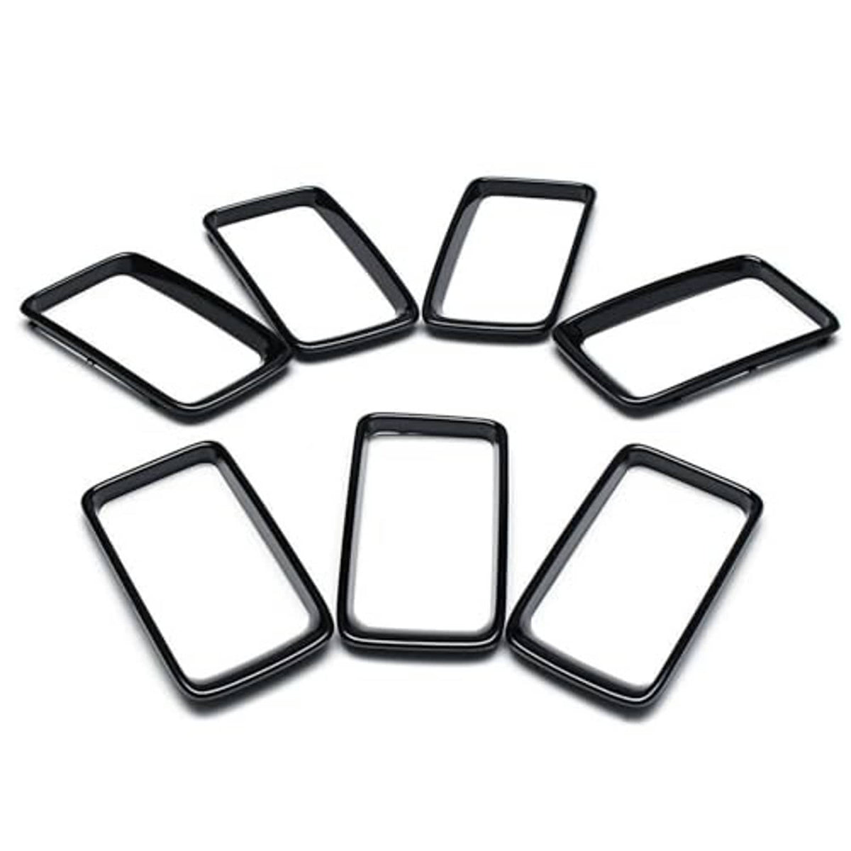 Seven black grille vent insert trim rings with chrome border, flat lay