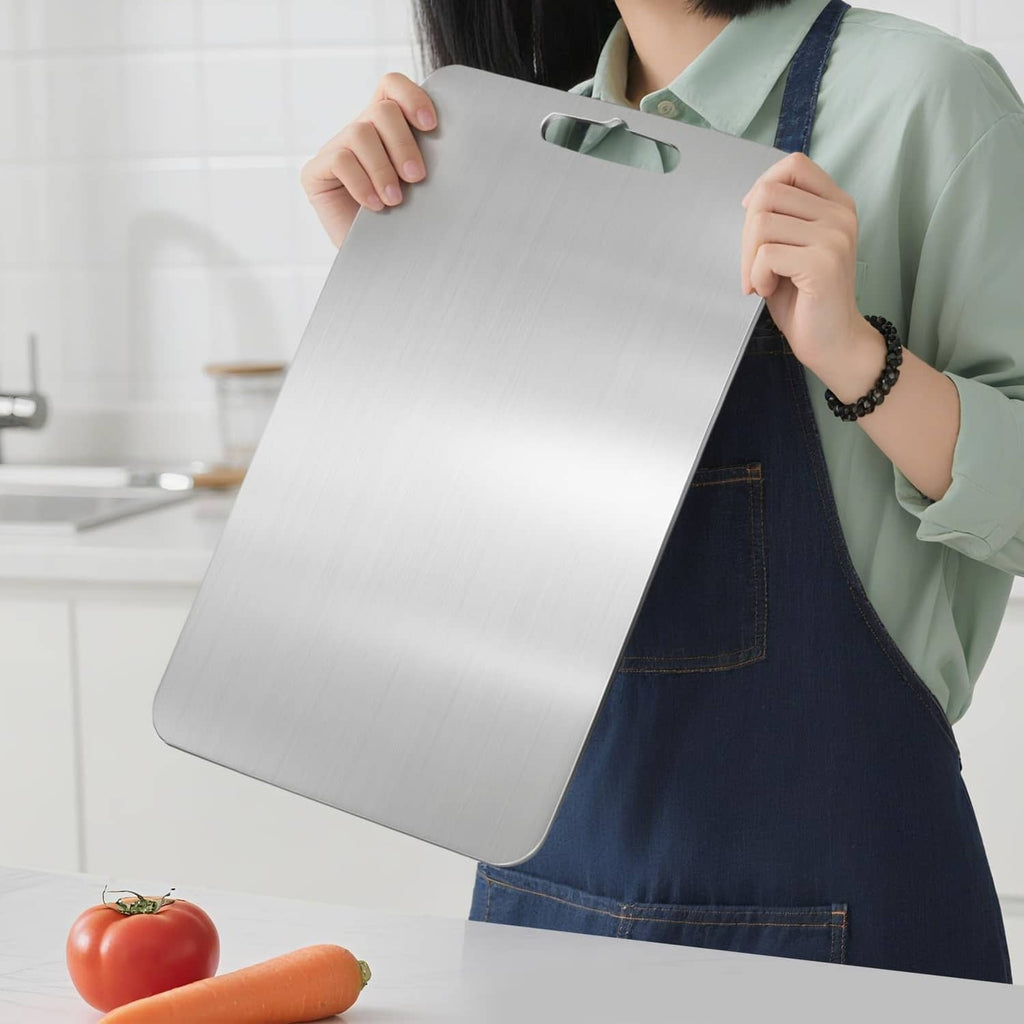 Silver titanium cutting board with hanging slot, held for kitchen prep