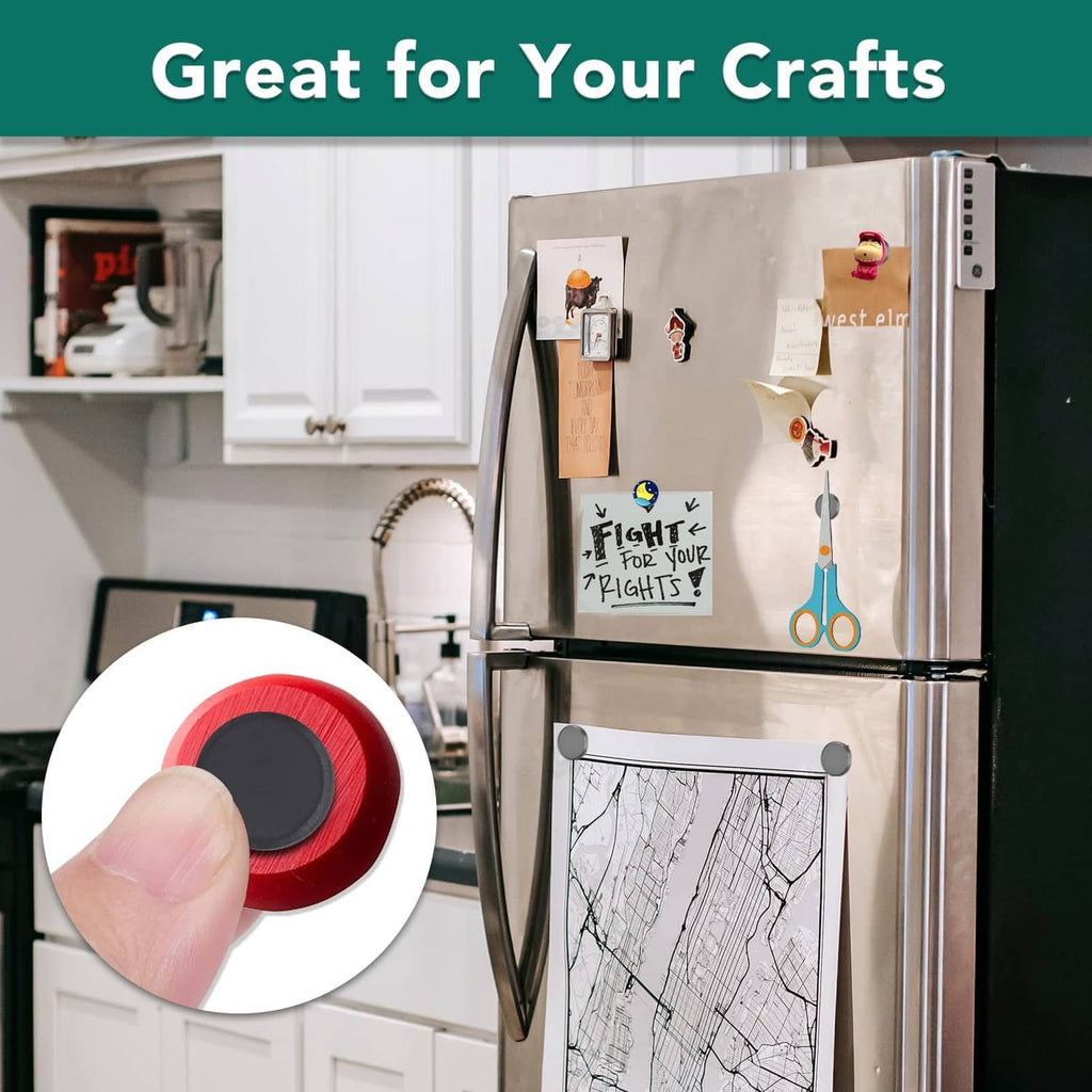 Hand holding a round dark gray disc magnet against a refrigerator door