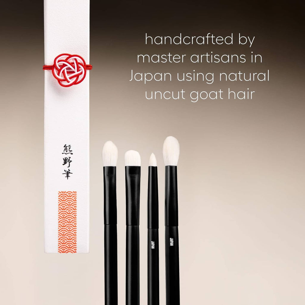 Four black eye makeup brushes with cream goat-hair bristles on display