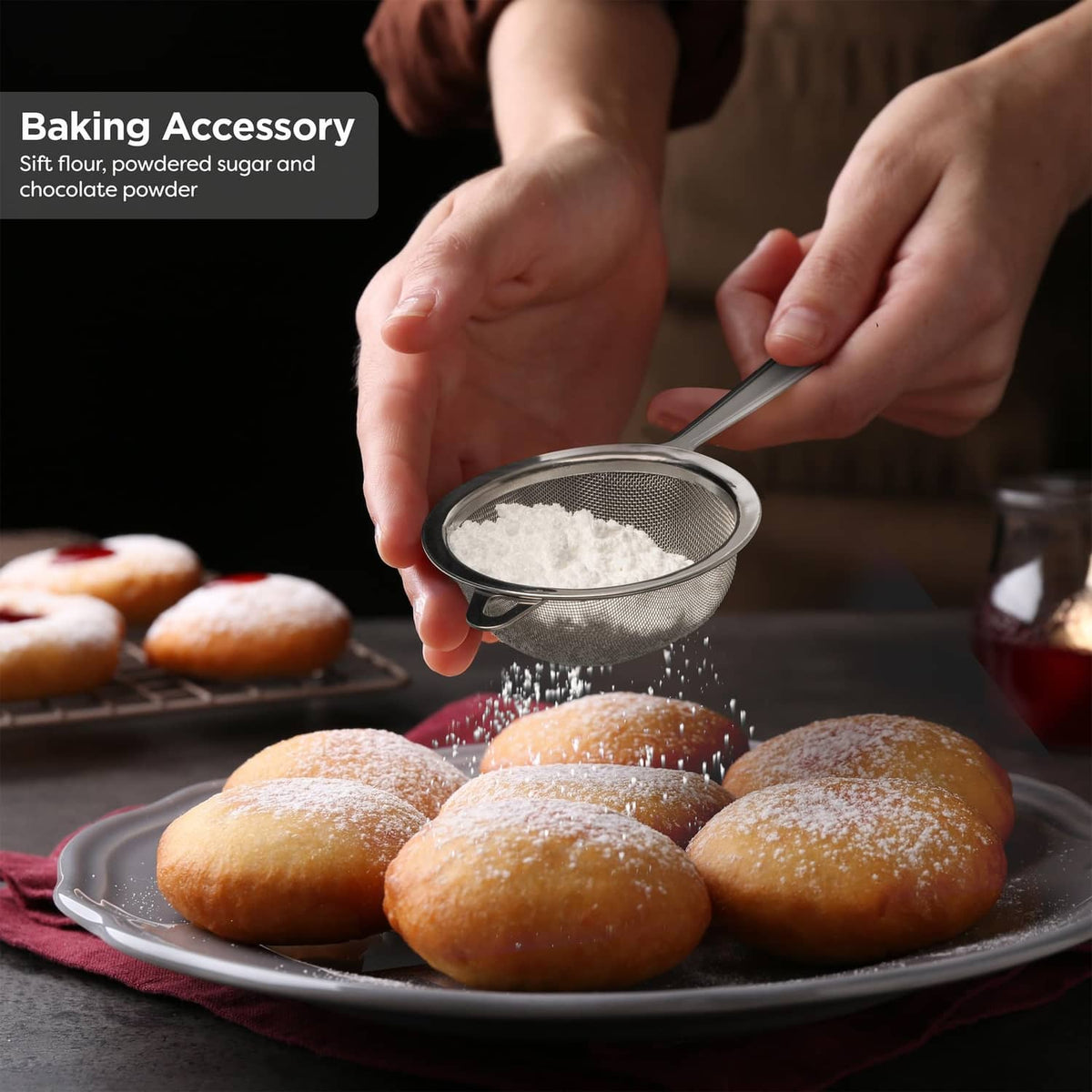 Stainless steel fine-mesh sifter dusting powder over pastries