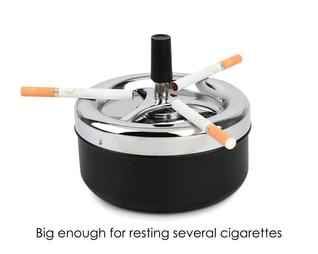 Black round ashtray with chrome spinning tray and upright holder; cigarettes resting