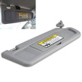 Grey passenger-side right sun visor with warning label and mounting tab