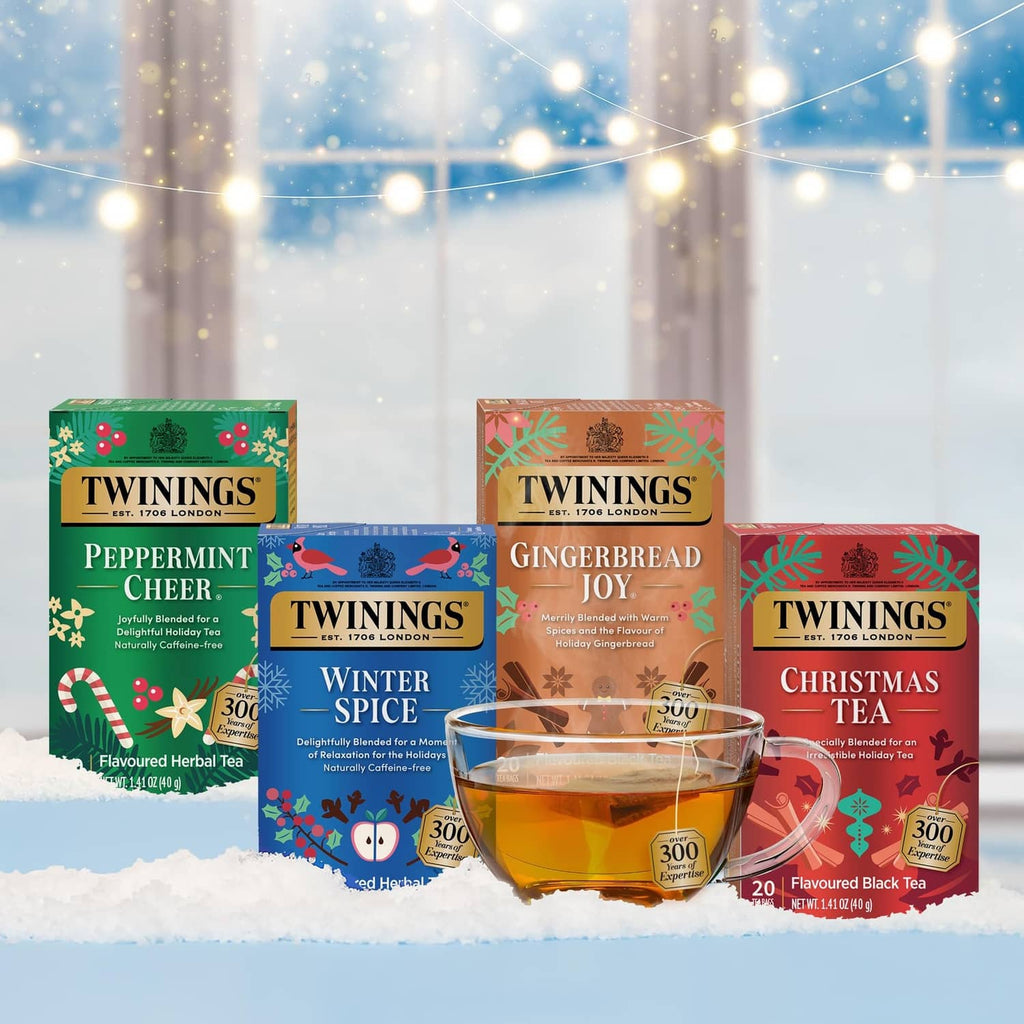 Assorted holiday tea bag cartons with a glass cup of tea in front