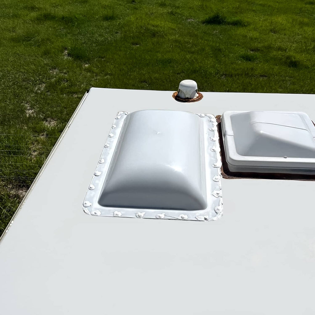 White camper skylight cover installed on roof opening with surrounding mounting border