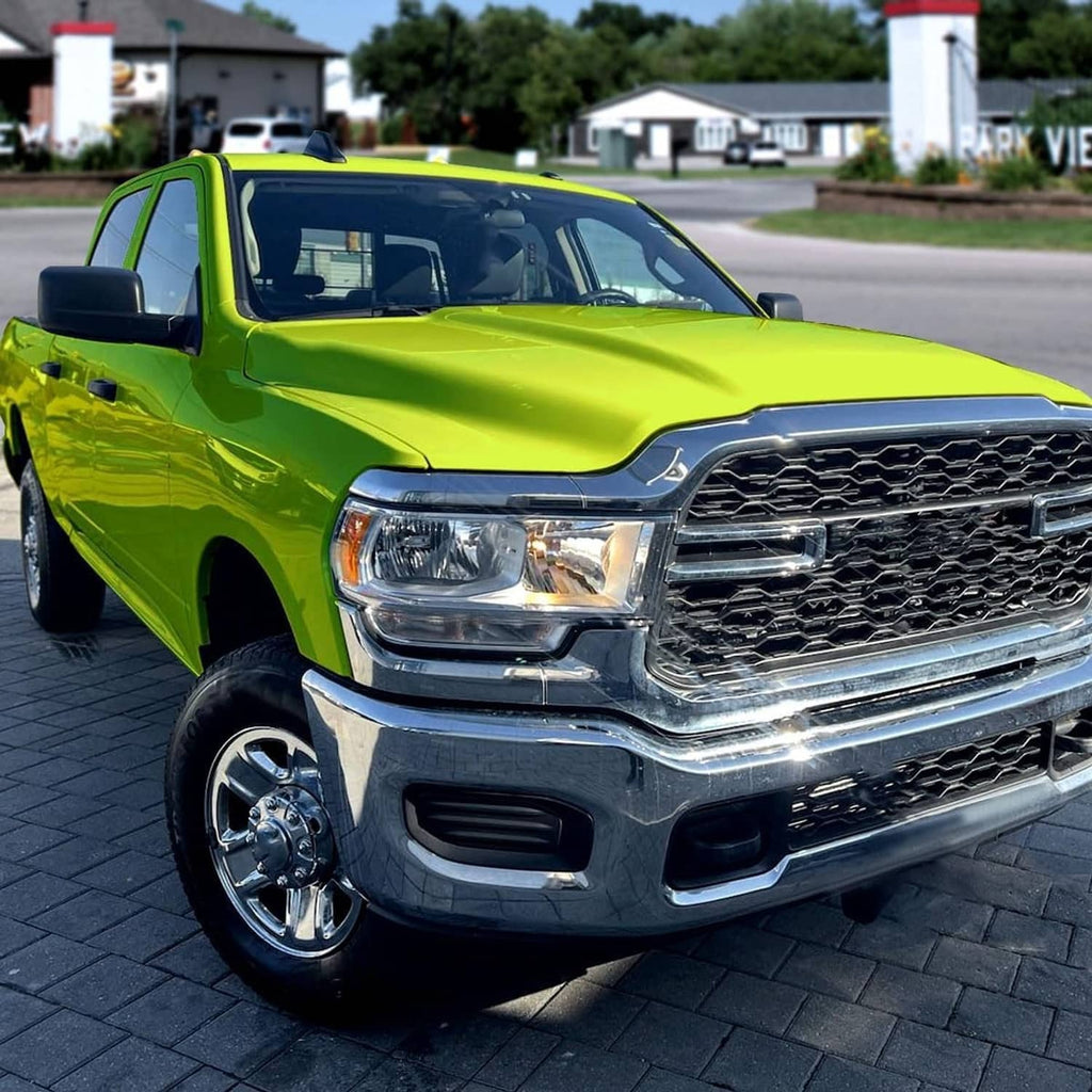 Right halogen chrome headlight installed on a green pickup truck front