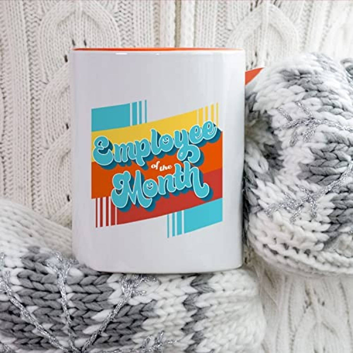 White ceramic mug with 'Employee of the Month' graphic, orange rim inside