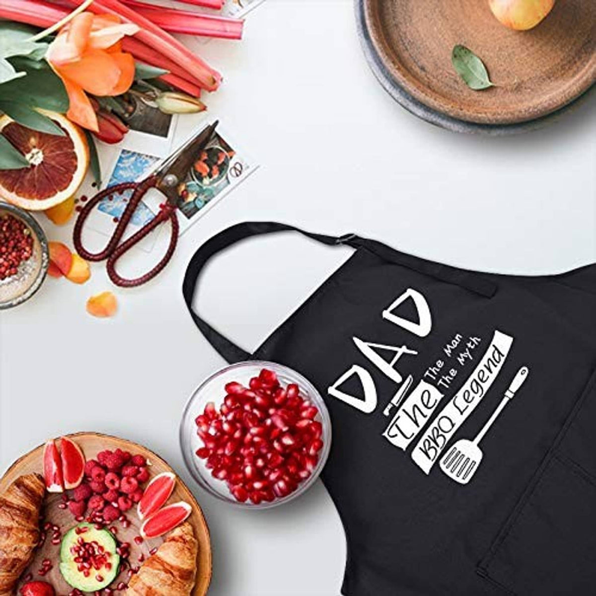Black BBQ apron with 'DAD The Man The Myth BBQ Legend' text and neck strap