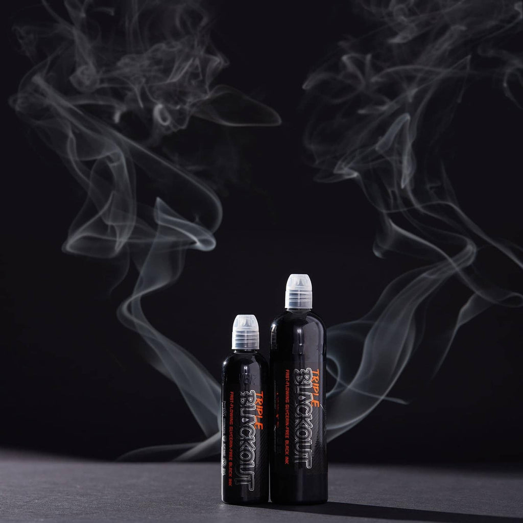 Black tattoo ink bottles standing with swirling white smoke