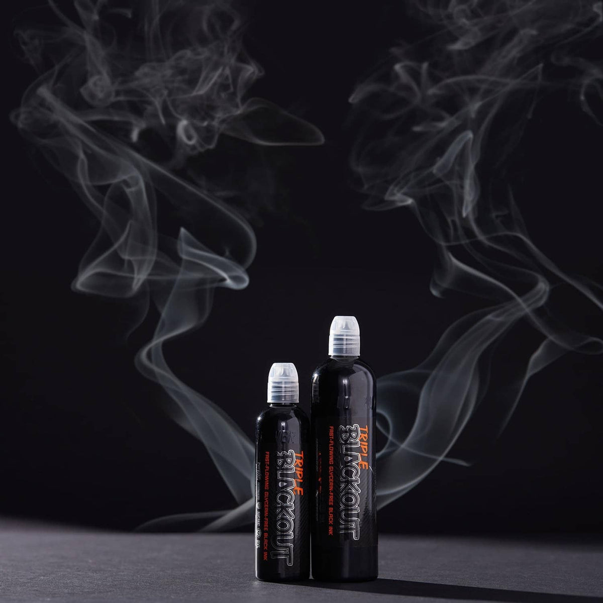 Black tattoo ink bottles standing with swirling white smoke