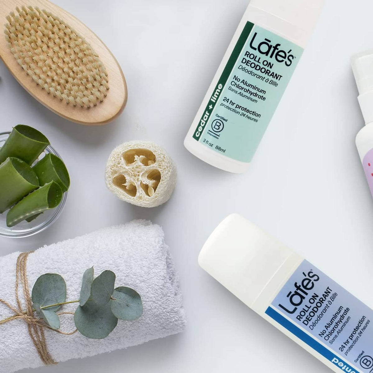 Lafe's roll-on deodorant bottle with towel, exfoliating sponge, aloe leaves and brush