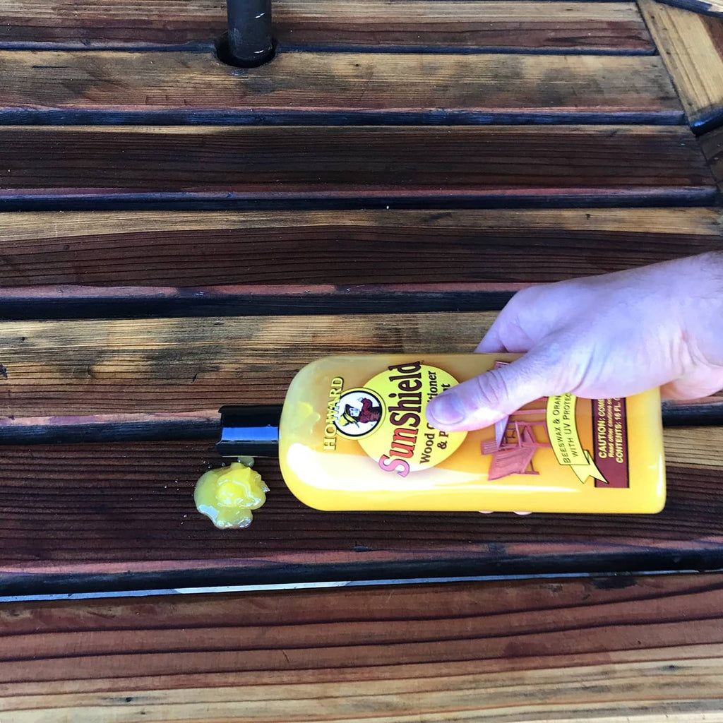 Hand applying Howard SunShield wax on wood outdoor chair slats