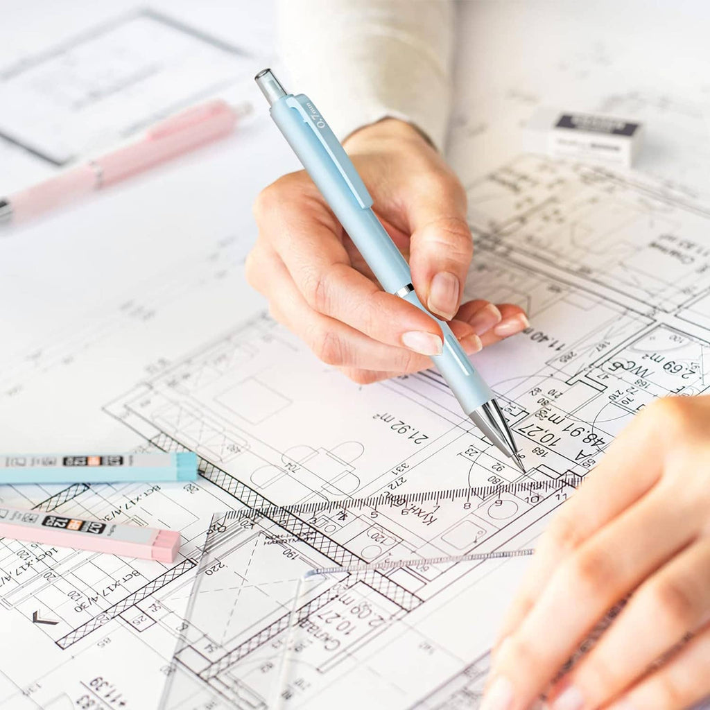 Hand writing with a light blue mechanical pencil on architectural drawings
