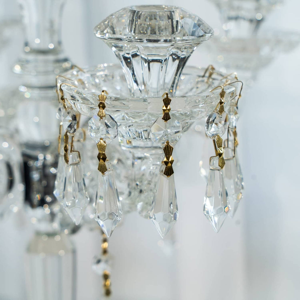 Close-up of clear faceted crystal drop connectors with gold caps and hanging links