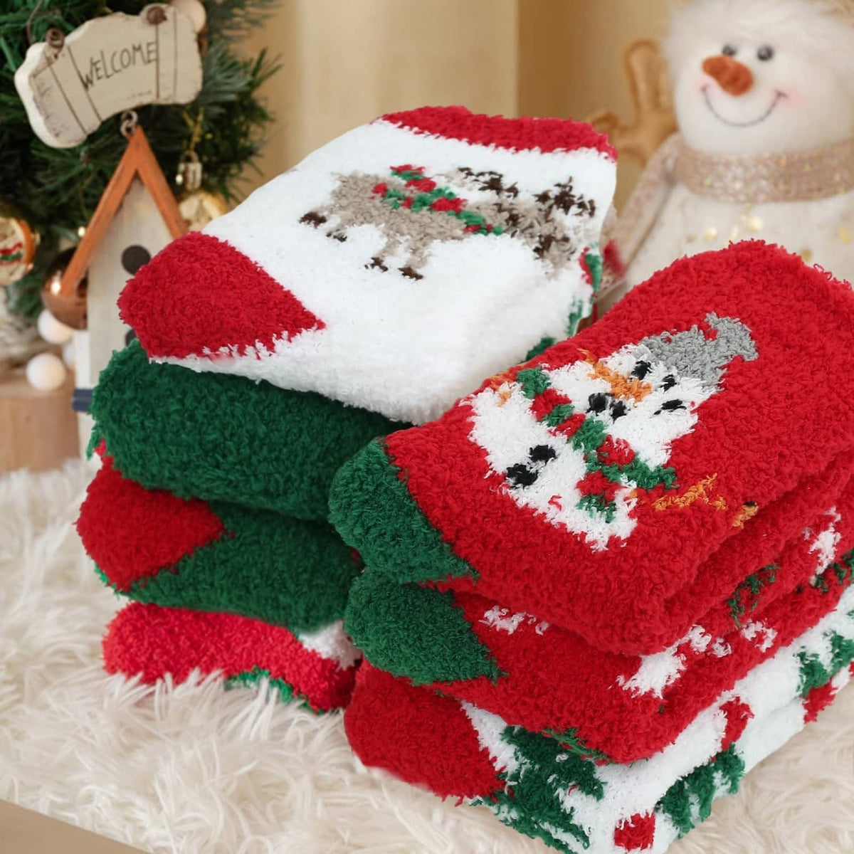 Padded Christmas crew socks folded together, featuring snowman and tree patterns in red and green