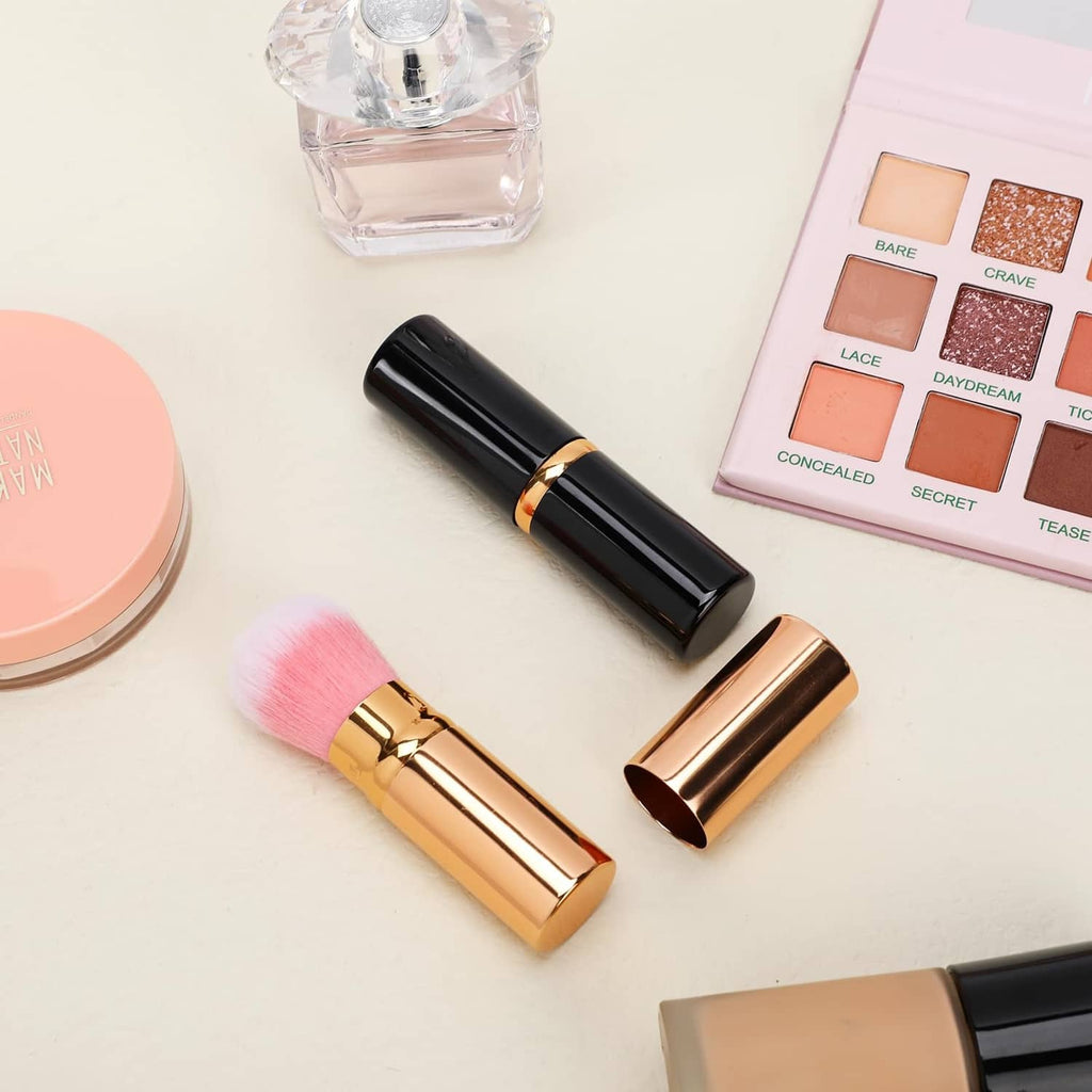 Two retractable blusher brushes with pink bristles, black handles and gold covers