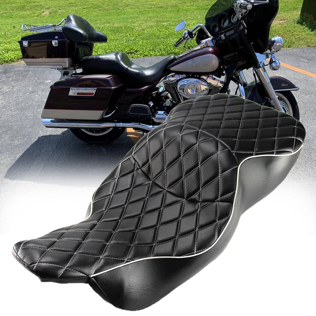 Black quilted motorcycle seat with silver piping on contoured rider surface, side view