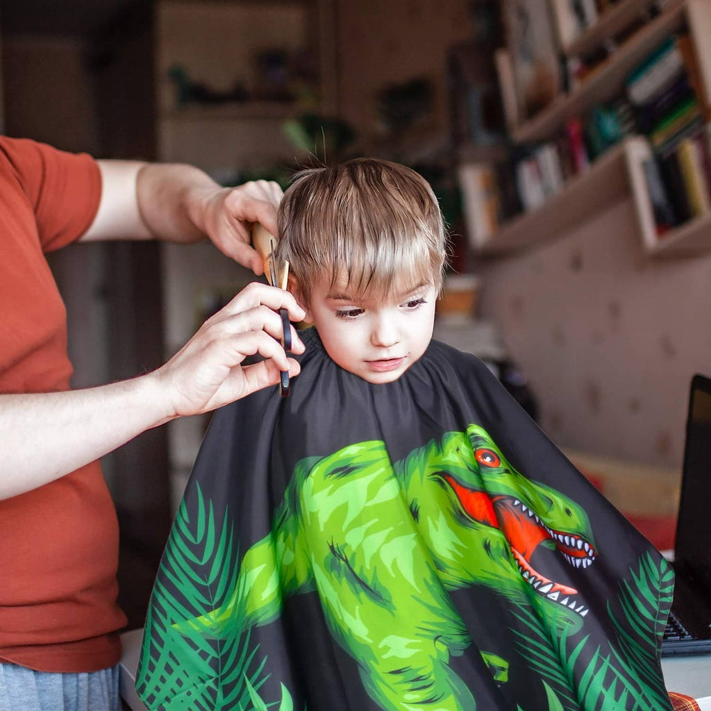 Kids waterproof haircut cape on child, black cape with green dinosaur print