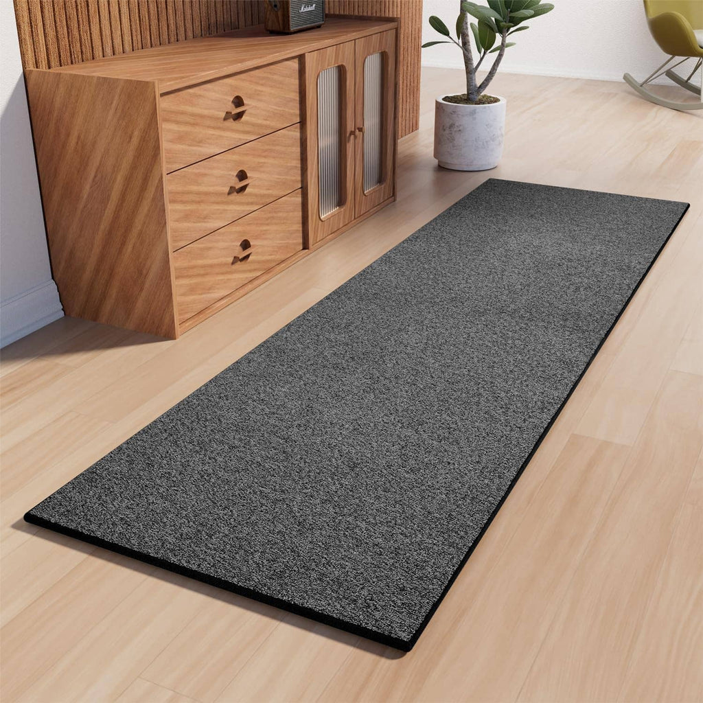 Charcoal gray textured runner rug with black bound edges on light wood floor