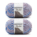 Two Bernat super bulky yarn skeins in dappled blue, lilac, and gray color mix