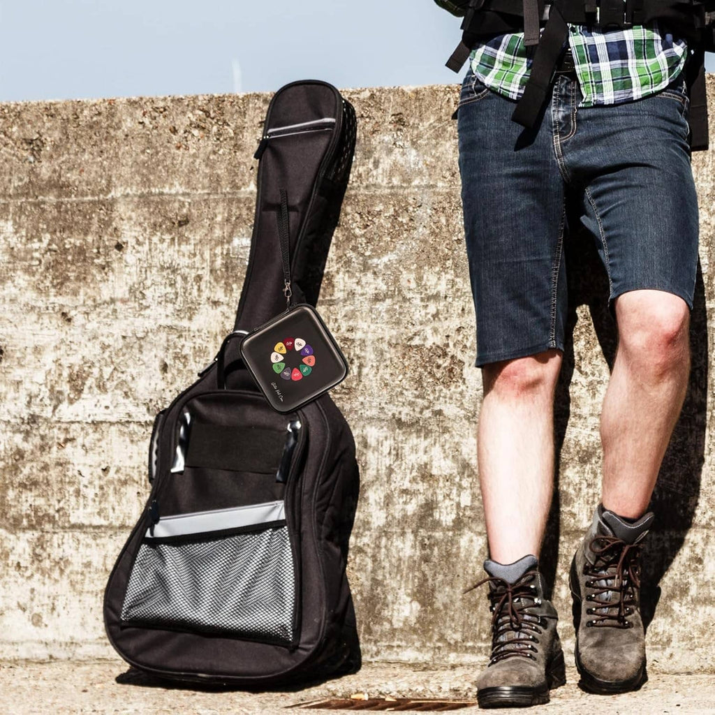 Compact black guitar pick holder case with strap attachment for carrying on a bag