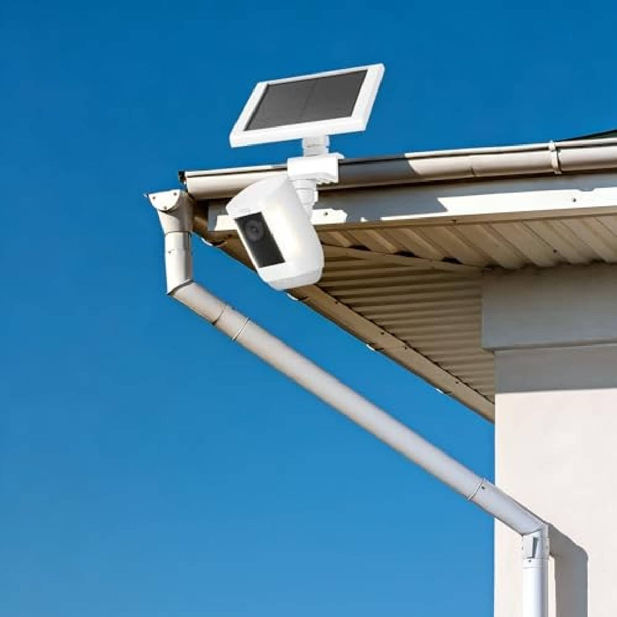 Outdoor white gutter mount with solar panel and camera installed on eave