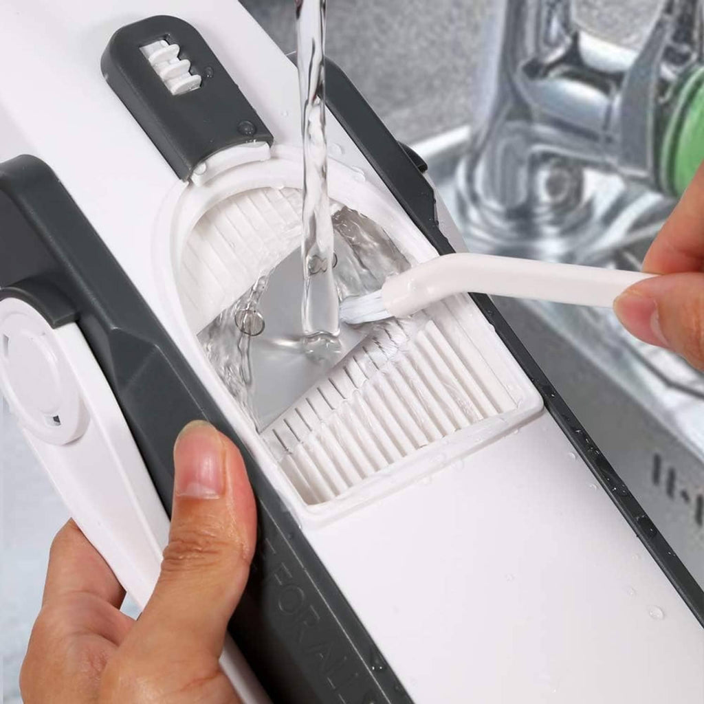 Mandoline slicer in use with safety carriage and blade guard over a cutting surface