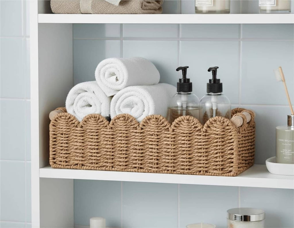 Scalloped woven rattan basket holding stacked white towels and soap bottles