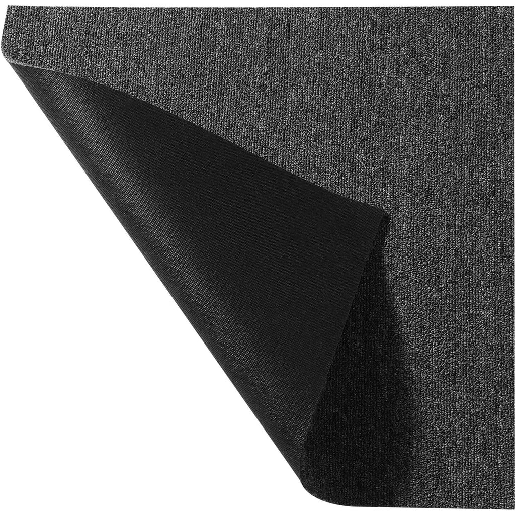 Dark gray carpet tile edge showing attached backing padding, textured fabric