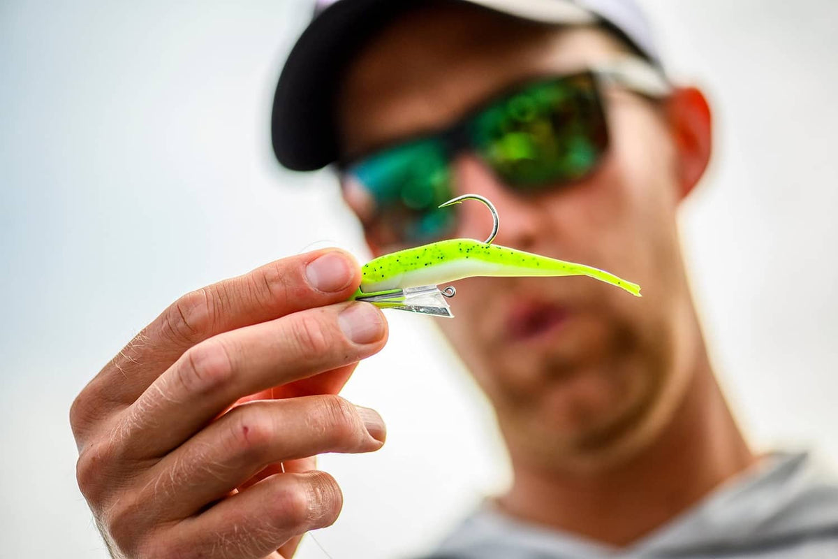 Chartreuse minnow soft fishing lure held in hand, silver hook visible