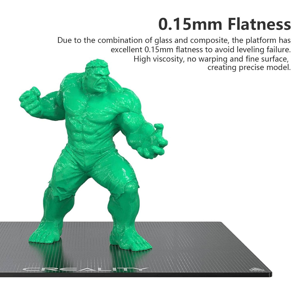 Creality glass bed platform with green test print figurine on gray surface