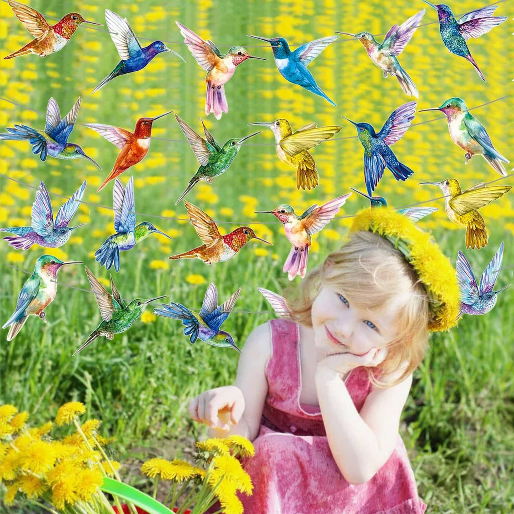 Colorful hummingbird string banner with multicolor bird cutouts above child in garden