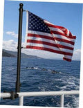 Black boat flag pole with attached American flag, mounted with clamp on rail