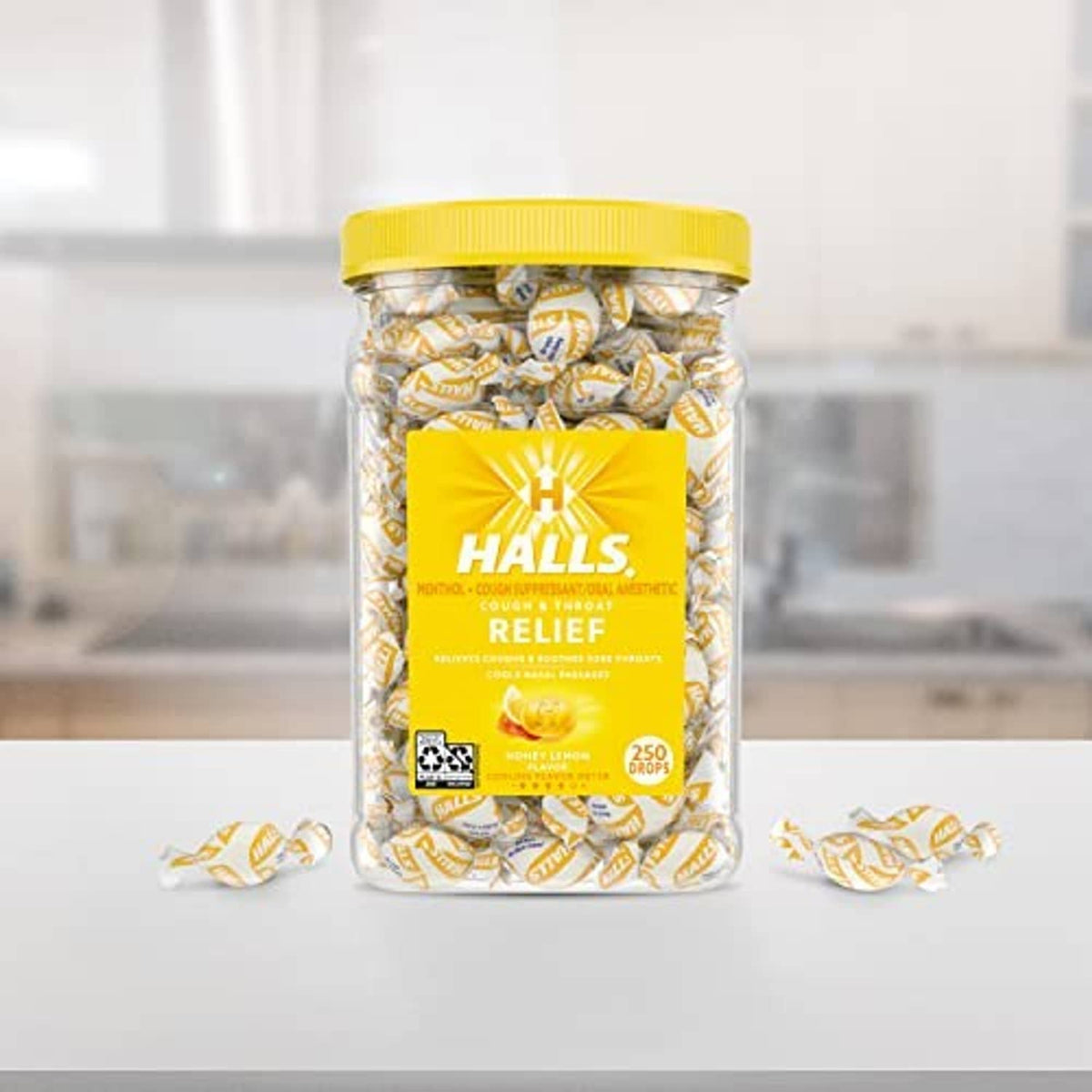 Halls Relief cough drops jar with yellow lid and wrapped candies on table