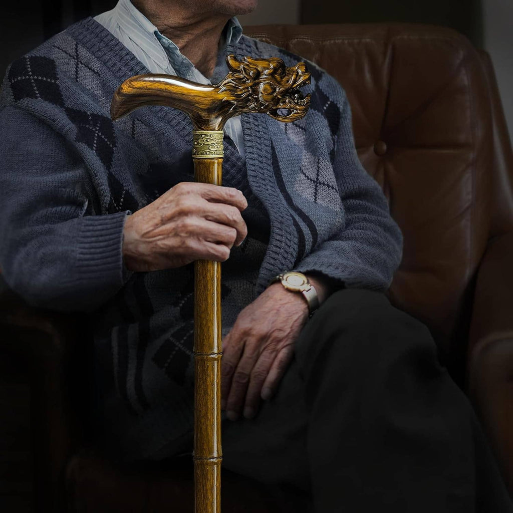 Wooden walking cane with ornate dragon handle, held by person while seated