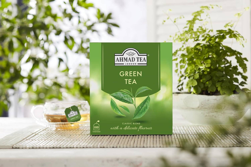 Ahmad Tea Green Tea box on a woven mat with a small teabag