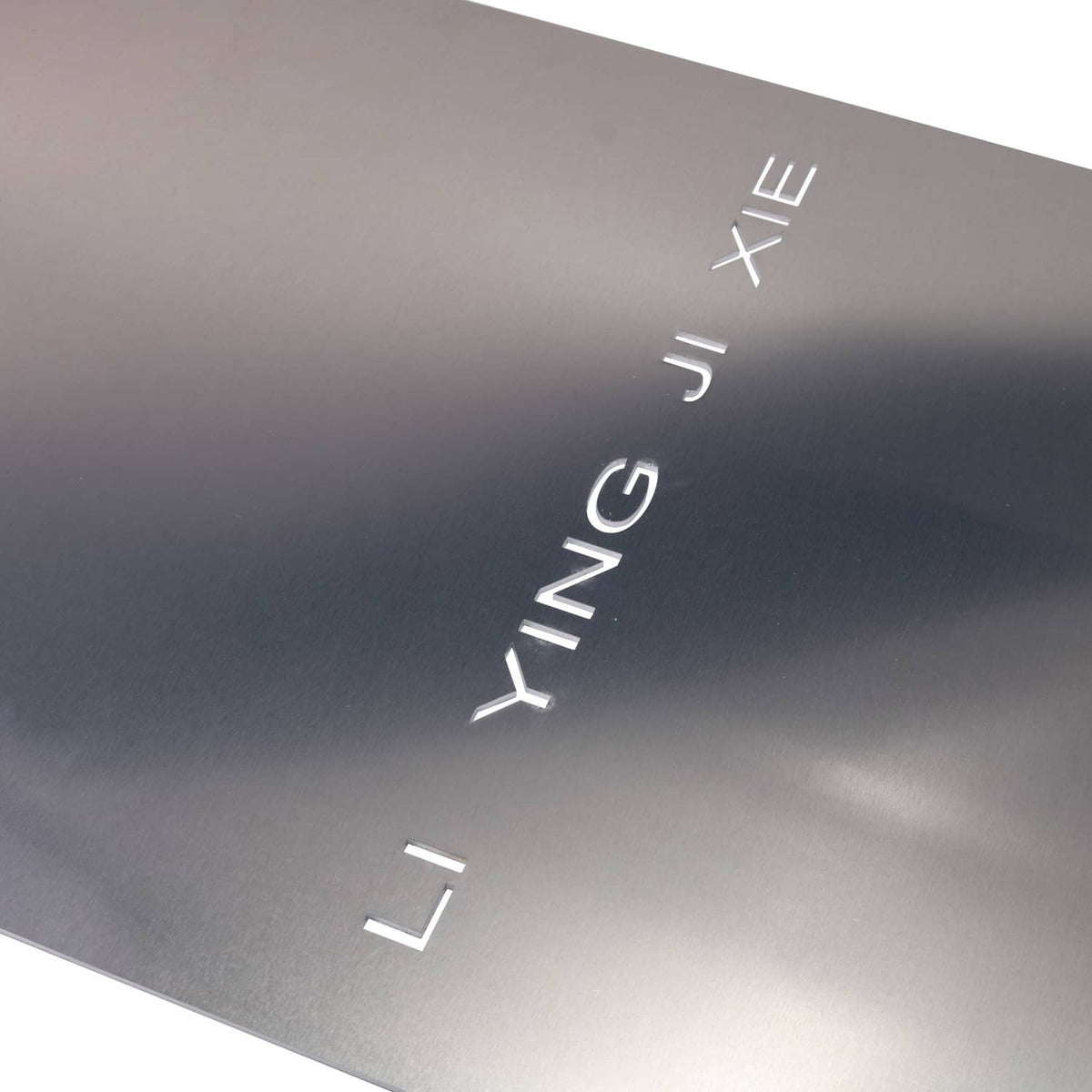 Dark gray metal catalytic converter shield plate with white logo cutouts