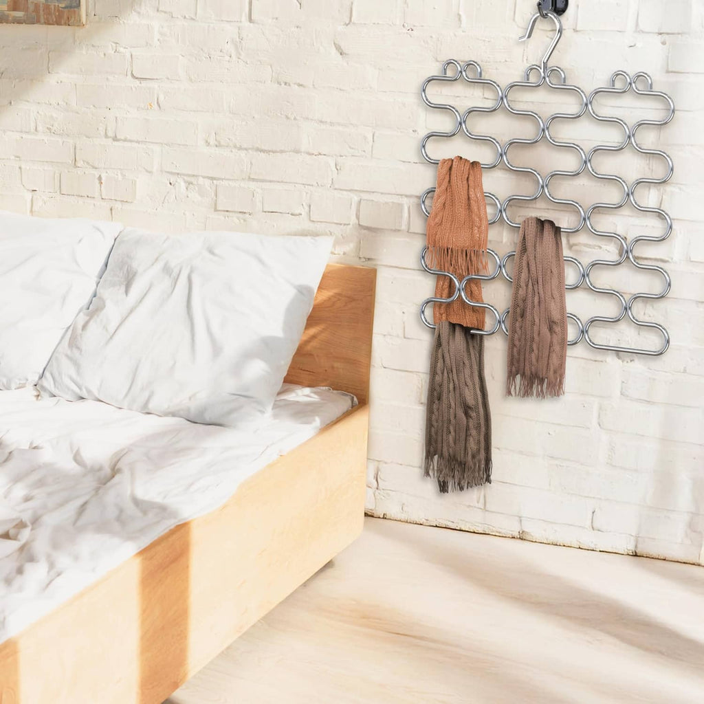 Chrome scarf hangers holding tan and brown scarves on a wall